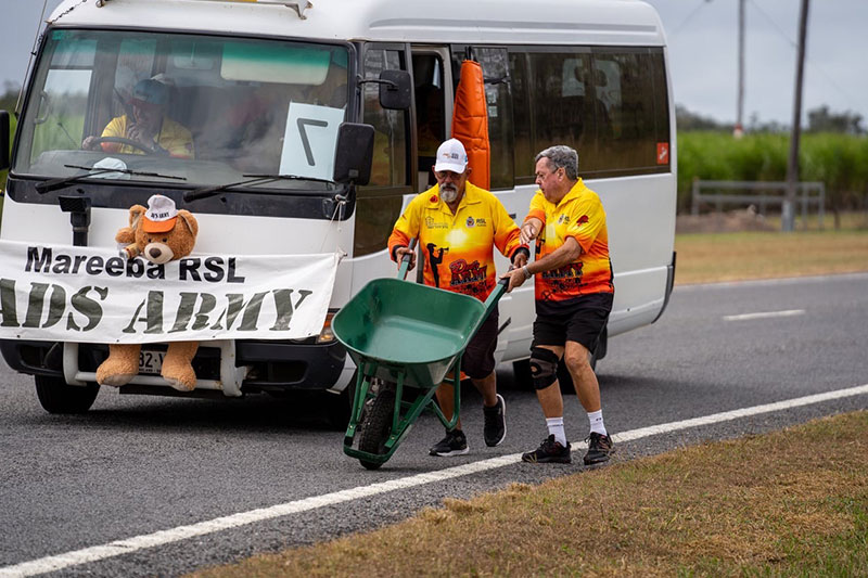 Image: Mareeba Shire Council | Ivan Sayed hands off wheelbarrow to Peter Gerdes during the Great Wheelbarrow Race 2024.