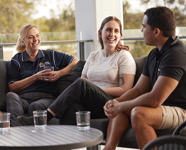 Veterans and RSL Queensland staff sitting together on an outdoor couch